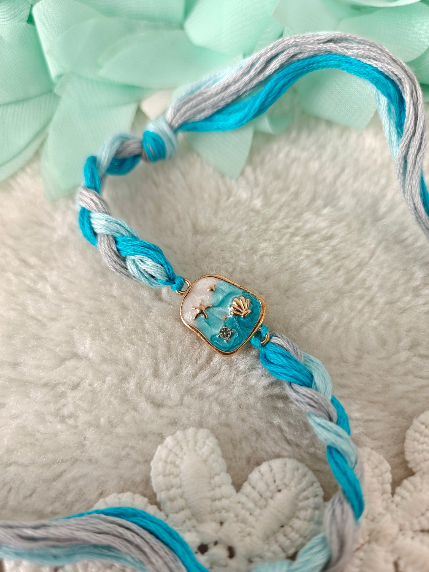 aqua ocean themed rakhi with shell charm and braided blue threads