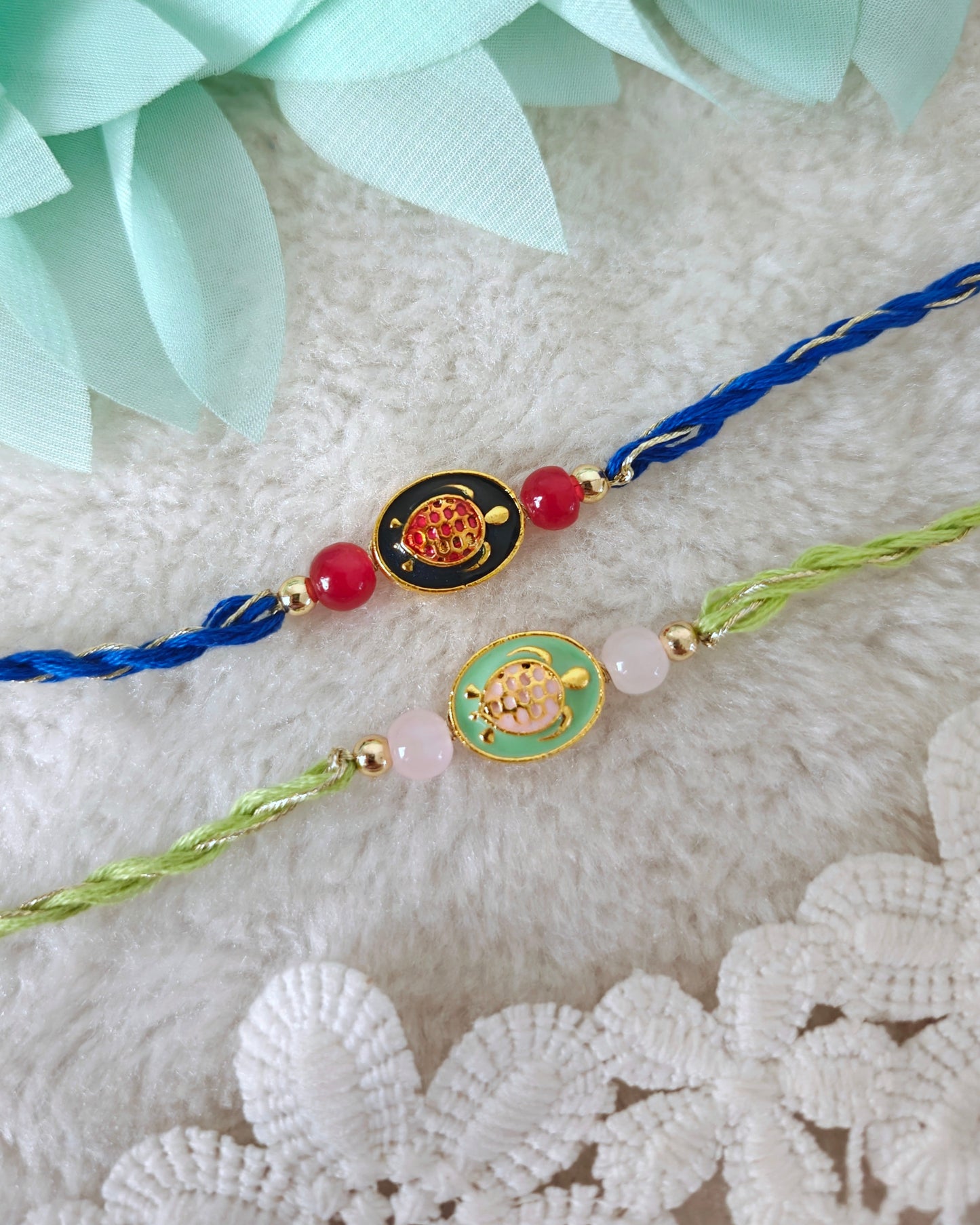 Minimal tortoise rakhi with oval charm, bead accents and twisted threads on soft background