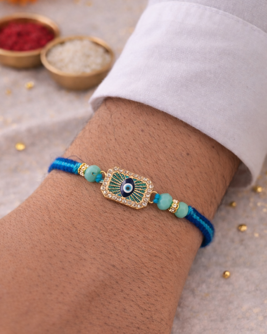 rakhi Bracelet with an eye design on a wrist, with a blurred background of small bowls and decorative items.
