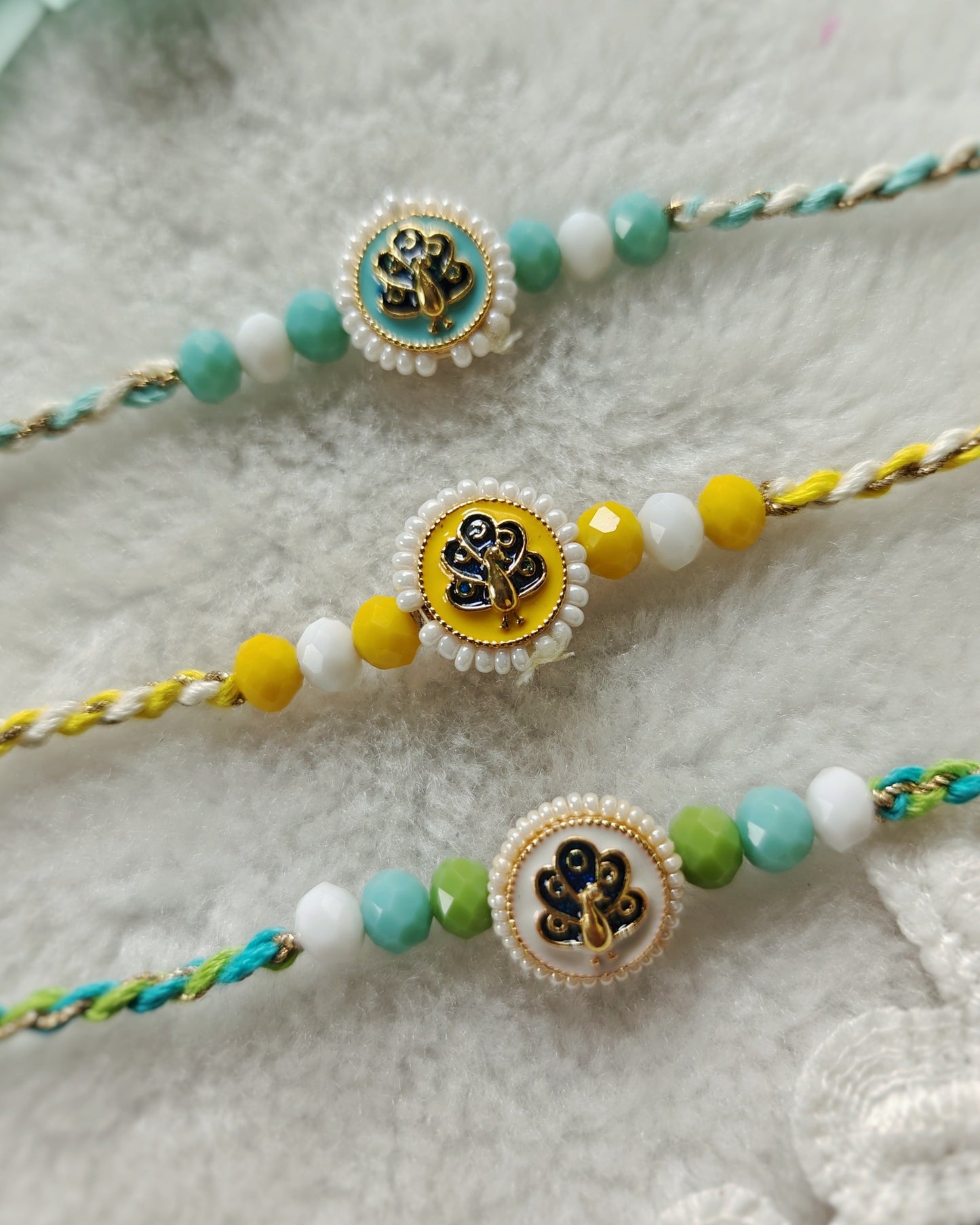 Peacock motif rakhi with blue green beads and white center bead on elegant thread, handmade rakhi for brother