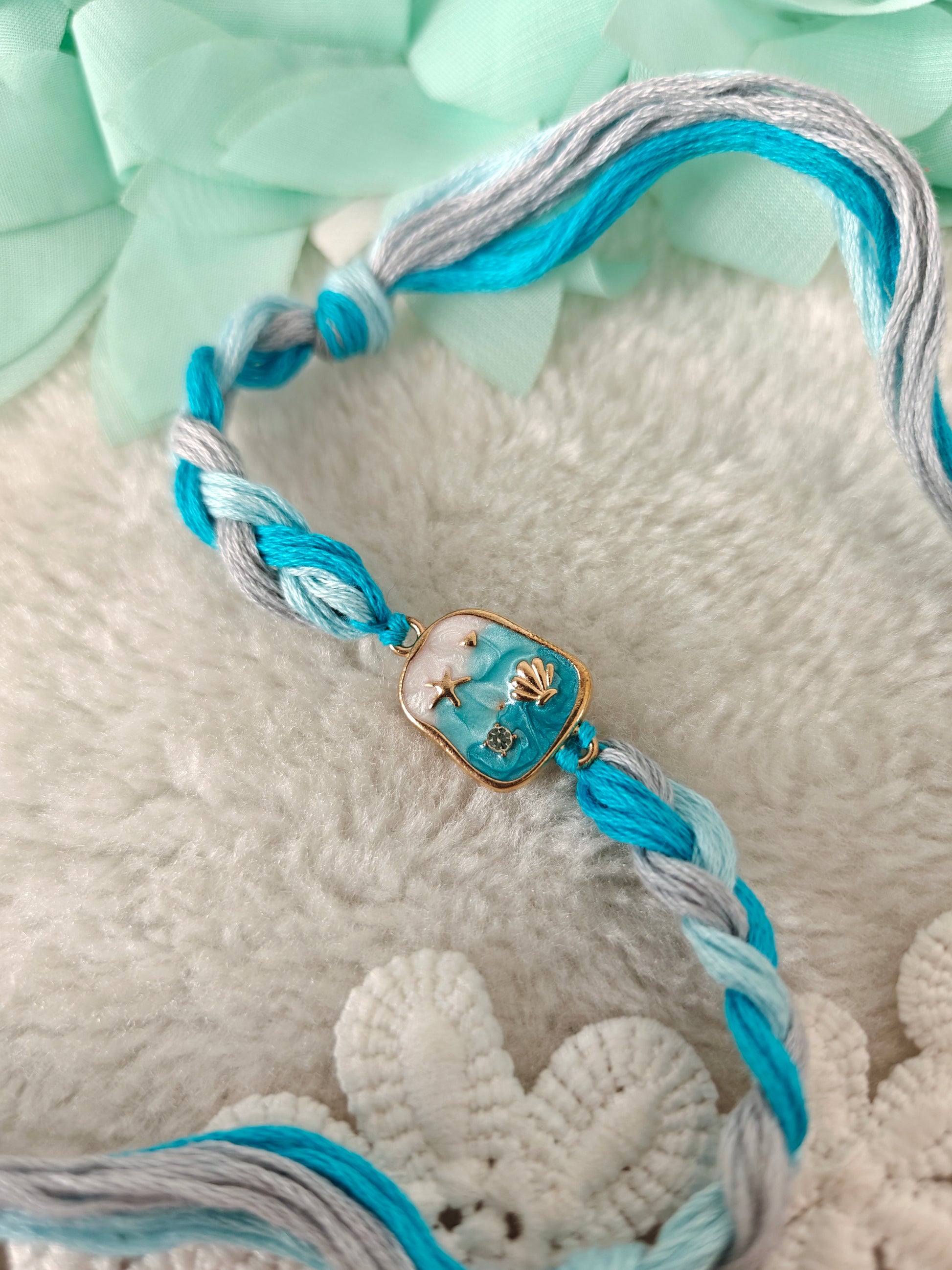 aqua ocean themed rakhi with shell charm and braided blue threads