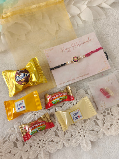 Designer rakhi hamper with assorted candies, roli chawal pack, and organza gift pouch for Raksha Bandhan.